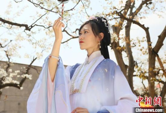 圖為蘭州青年身穿漢服在百年梨園賞景?！「哒?攝