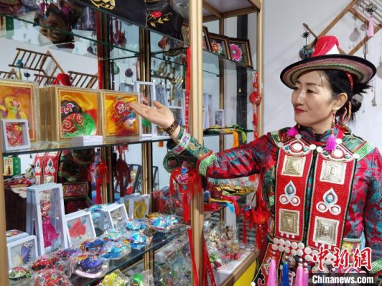 圖為身著民族服飾的隴原巧手展示手工藝品。(資料圖) 徐雪 攝
