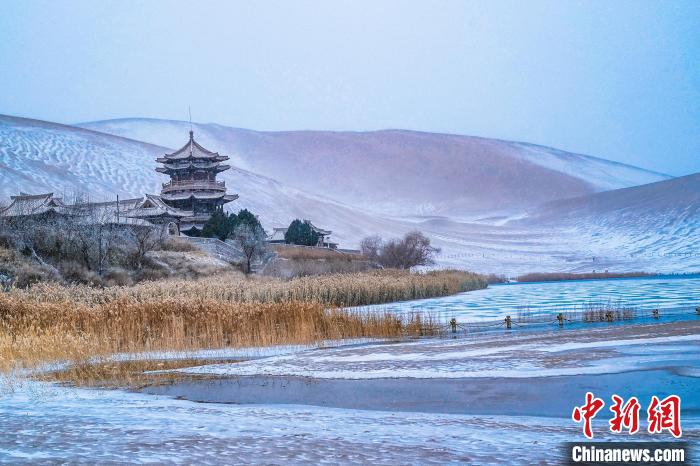 2021年11月28日，雪落鳴沙山月牙泉景區(qū)?！⊥醣筱y 攝