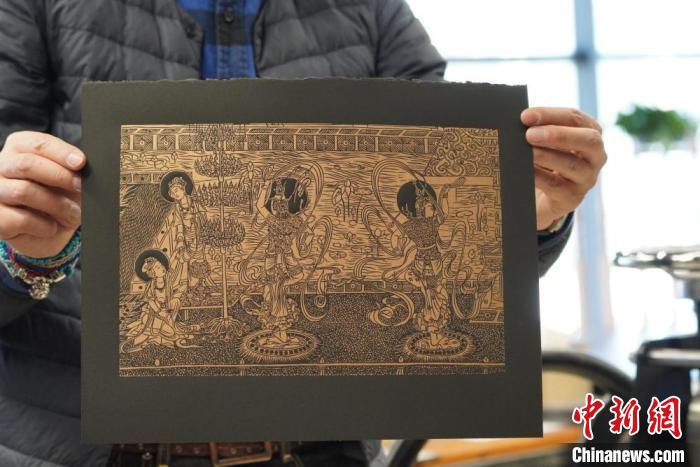 圖為手工書(shū)藝人展示敦煌雕版壁畫(huà)印刷品?！【琶赖┰?　攝