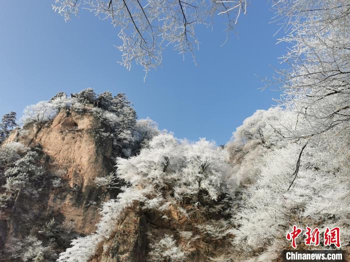圖為藍(lán)天下霧凇籠罩山脈?！⌒煺袢A 攝