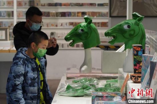 圖為“神馬來了”銅奔馬頭套吸引參觀者駐足?！【琶赖┰?攝