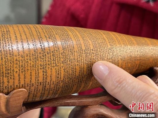 圖為長約二十公分的長條葫蘆雕刻佛教經(jīng)文作品?！堟?攝