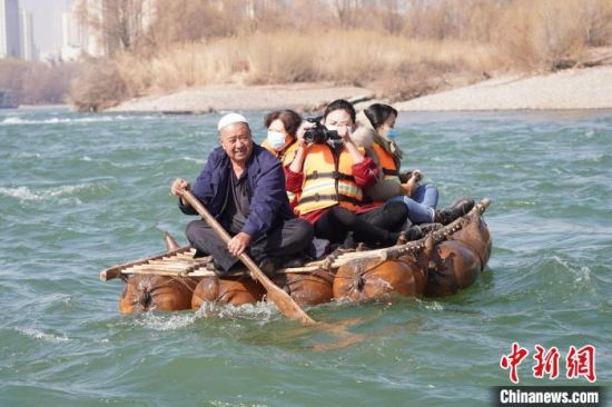 2月24日，年過(guò)七旬的蘭州羊皮筏子制作技藝第三代傳承人張德寶在黃河上劃著羊皮筏子。(資料圖) 九美旦增 攝