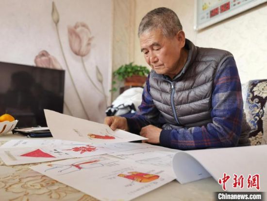 圖為陸鵬飛向記者展示多年帶隊(duì)的手寫(xiě)筆記?！堟?攝