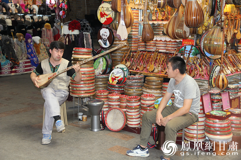 烏魯木齊二道橋巴扎內(nèi)，店主正在向客人展示樂(lè)器。楊文遠(yuǎn) 攝