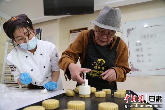 當(dāng)日，受邀參加活動的臺胞臺屬代表、兩岸婚姻及子女、在甘臺商代表等歡聚一堂。圖為77歲的在甘臺胞潘天鑒制作月餅。九美旦增 攝