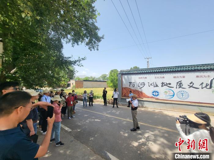 圖為中國(guó)地質(zhì)大學(xué)(北京)教授張緒教介紹村落情況?！『衍?攝