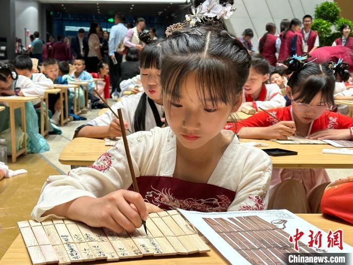 圖為小朋友在甘肅簡牘博物館練習書法?！≈行律缬浾?戴文昌 攝