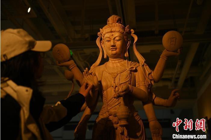 圖為季茂杰觀察自己創(chuàng)作的敦煌木雕。李亞龍 攝</p>
<p>