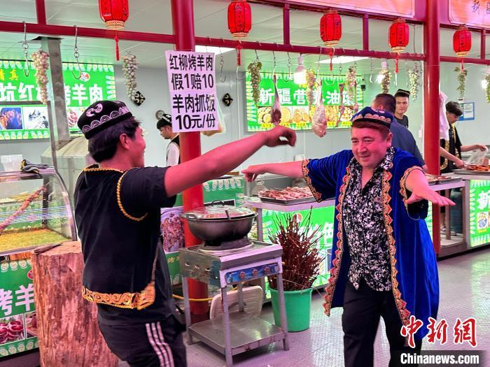 圖為餐飲經(jīng)營者在“西涼不夜城”跳起舞蹈引客?！〈魑牟?攝</p><p>