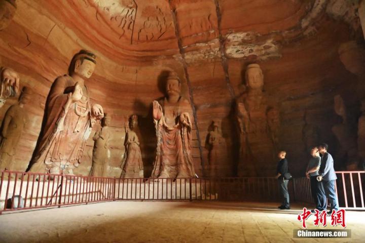 7月15日，游人參觀甘肅省平?jīng)鍪袥艽h百里石窟長(zhǎng)廊中的南石窟寺1號(hào)窟。百里石窟長(zhǎng)廊位于涇川縣境內(nèi)，由512個(gè)石窟、5眼窟中石井組成，現(xiàn)存王母宮石窟、鳳凰山石窟、南石窟寺、丈八寺石窟、羅漢洞石窟、太山寺石窟等規(guī)模較大的石窟群，還有數(shù)量眾多的小石窟群。南石窟寺開(kāi)鑿于北魏永平三年，其中1號(hào)窟屬于大型七佛窟，七佛高達(dá)6米。中新社記者 李亞龍 攝