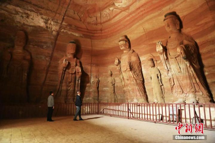 7月15日，游人參觀甘肅省平?jīng)鍪袥艽h百里石窟長(zhǎng)廊中的南石窟寺1號(hào)窟。百里石窟長(zhǎng)廊位于涇川縣境內(nèi)，由512個(gè)石窟、5眼窟中石井組成，現(xiàn)存王母宮石窟、鳳凰山石窟、南石窟寺、丈八寺石窟、羅漢洞石窟、太山寺石窟等規(guī)模較大的石窟群，還有數(shù)量眾多的小石窟群。南石窟寺開(kāi)鑿于北魏永平三年，其中1號(hào)窟屬于大型七佛窟，七佛高達(dá)6米。中新社記者 李亞龍 攝